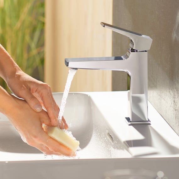 Mitigeur chromé hansgrohe au-dessus d’un lavabo blanc